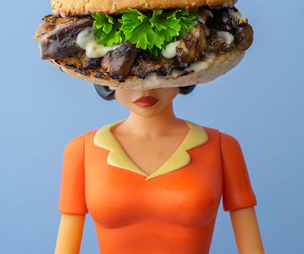 Een pop met een broodje jerk paddenstoelen met mayonaise en peterselie als hoofd.